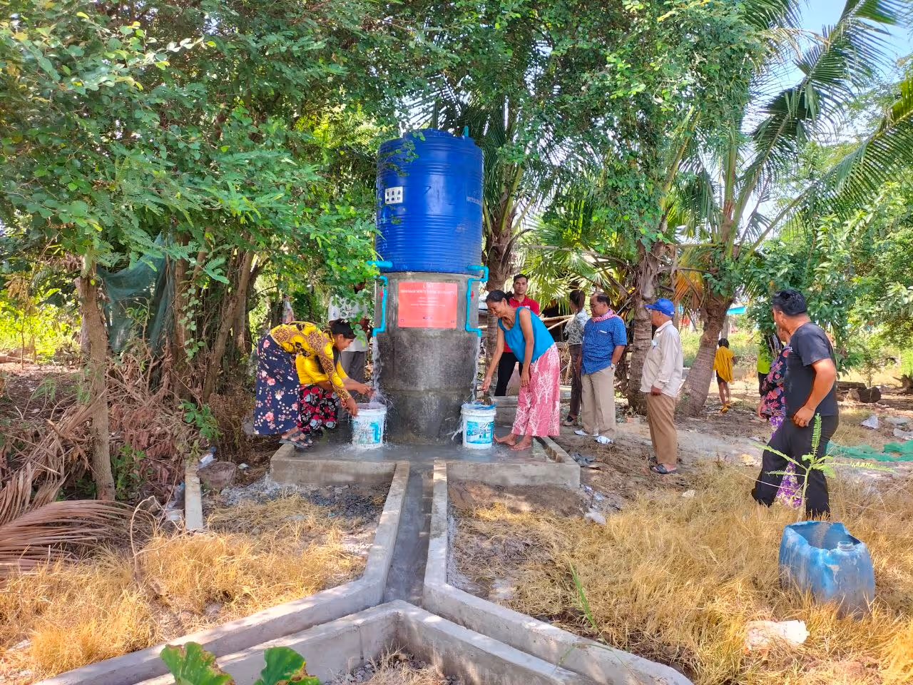 Deux villageoises remplissent leurs seaux au réservoir d'eau installé par LIFE dans un village cambodgien.