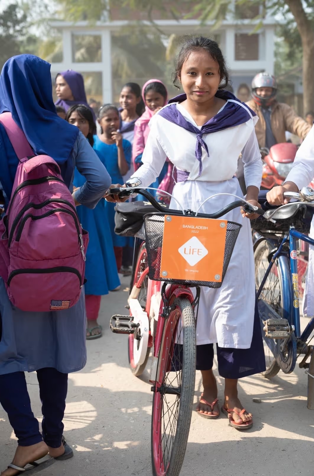 Une collégienne du Bangladesh tient le vélo remis par LIFE pour lui permettre de rejoindre son école.